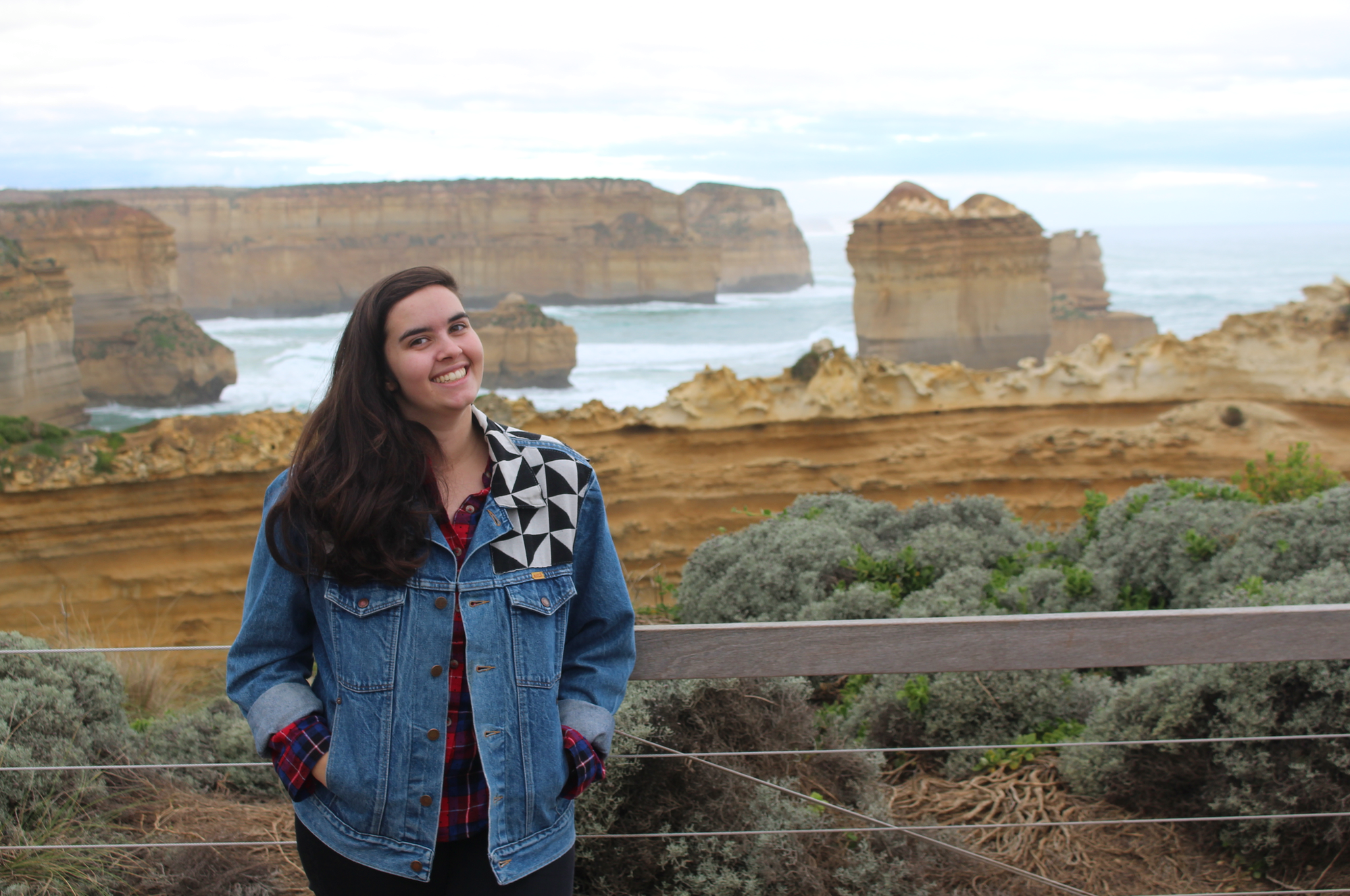 Beth standing in front of cliffs and the ocean in Australia.